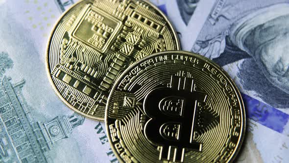 Bitcoin BTC coin rotate on 100 dollars USD bills. blockchain, mining GPU alt