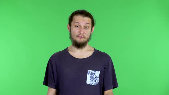 A Brunette in a Tshirt on a Green Screen Says Something Shows you and Me Then Makes a Gesture of alt