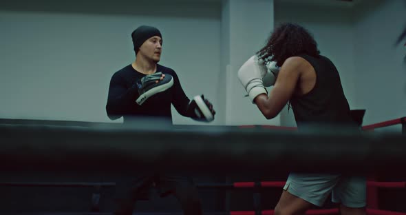 Tired Darkskinned Fighter is Punching Pads on Hands of Coach Workout in Fight Club  Prores alt