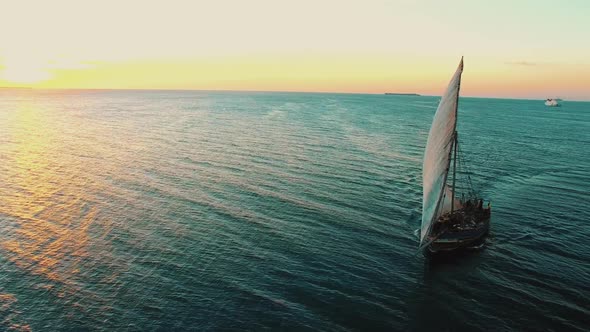 fishermen's wooden dhow sailing at sunset in Zanzibar alt