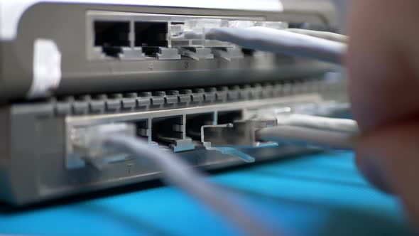 Hand Plugs Ethernet Cable Into Router alt