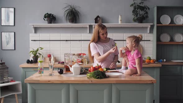 Beautiful Mother Cooking Dinner on Kitchen with Little Kid