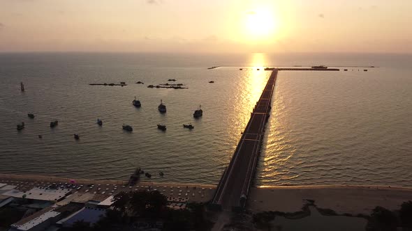Aerial View of the Ocean at Sunset with a Pier and Boats Near the Shore A Long Pier Near the City