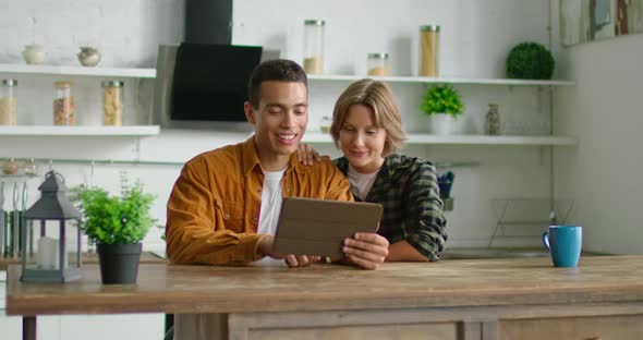 Latin Man and White Woman Talking Via Video Application on Tablet Computer alt