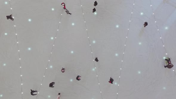 Aerial static view over flashing lights and people skating on ice rink in Zakopane. Poland alt