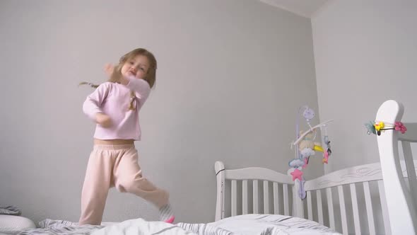 Funny Cute Little Girl Jumping and Having Fun on the Bed