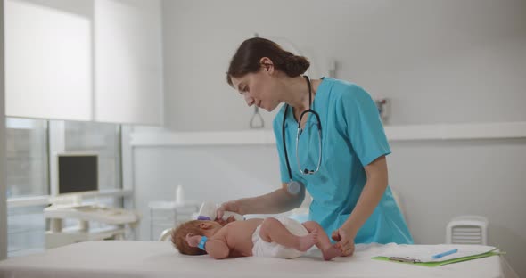 Doctor Measuring Temperature of Little Baby with Noncontact Thermometer in Clinic alt