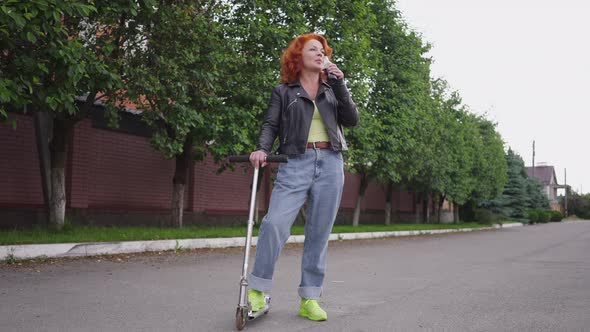 Wide Shot Confident Gorgeous Retro Woman Standing Outdoors with Kick Scooter Drinking Soda Water in alt