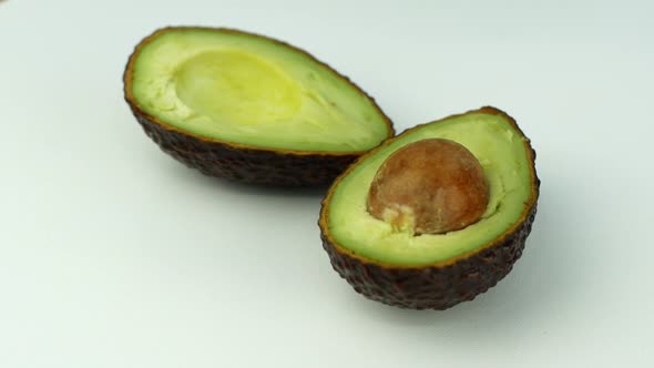 Avocado rotates on a green grass background. 4K video close-up of wholesome and healthy food. alt