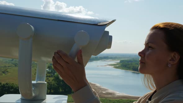 Young Woman Looking Through Big Street Binoculars alt