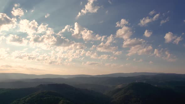 Aerial time lapse of morning clouds at sunrise, over hills