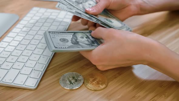 Female Hands Counting Cash with Bitcoins. Crop View of Woman Hands Counting Large Bundle of Dollar alt