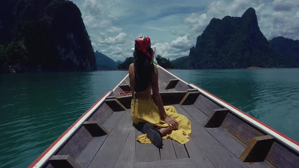 Cute Smiling Asian Sitting on a LongTail Boat in Cheow Lan Lake Thailand