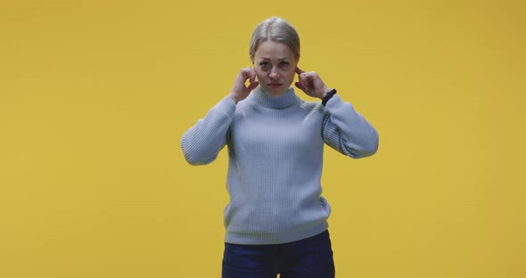 Woman Plugging Her Ears alt