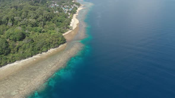 Aerial: flying over tropical Ai island white sand beach Banda Islands Indonesia alt