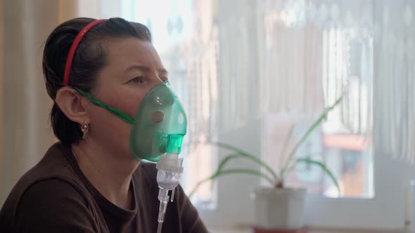 A European Woman at Home Carries Out Inhalation Inhalation of Oil Vapors Oxygen Through a Mask alt
