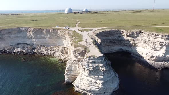 Drone footage of cliff and observatory moving back to reveal the sea