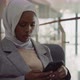 Black Woman in Hijab Surfs Internet on Smartphone in Office - VideoHive Item for Sale