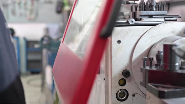 Close Up View of Worker Operating a High Precision Turning Operation on a Multi Axis Lathe CNC alt