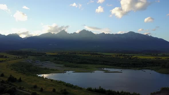 Drone aerial view of The High Tatras Mountain Range in Poprad, Slovakia, sunset golden hour. Wide sh alt