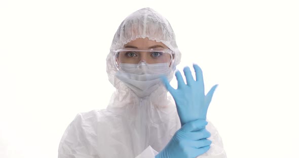 Portrait of Woman Dressing on Protective Suit Mask Gloves and Glasses on the White Background