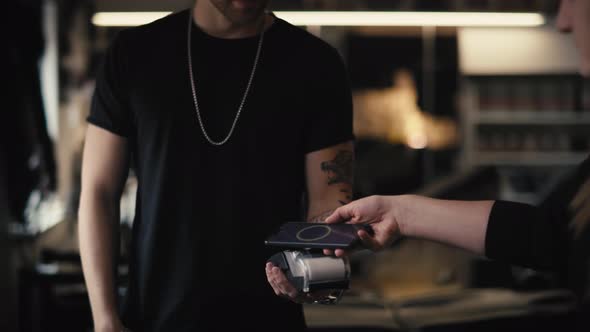 Caucasian man taking a pay in tattoo studio. Shot with RED helium camera in 8K. alt