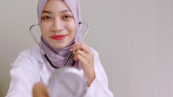 Doctor listening to patient's heart rate with stethoscope in clinic alt