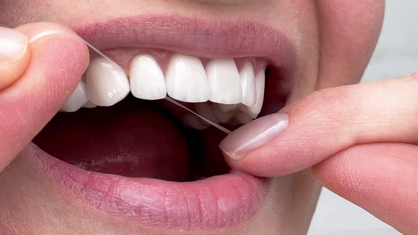 Closeup Woman Flossing Perfect White Teeth with Floss Toothcare Hygiene Teeth Cleaning Routine and alt