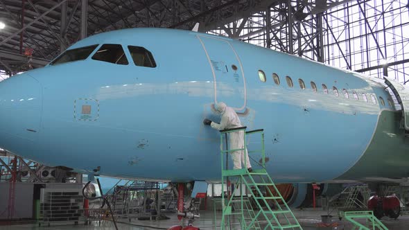 Painting the aircraft at the factory. The engineer repairing the aircraft alt