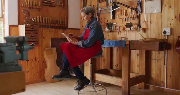 Female luthier at work in her workshop alt