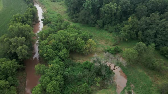 Aerial view of muddy creek waters after a storm in the midwest. Soggy muddy creek banks.