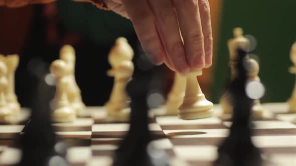 Chess board with a hand moving the white pawn