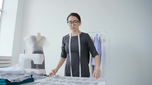 Concept of Hobby and Small Business. Young Female Seamstress Designs and Sews Clothes alt