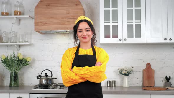 Portrait Smiling Housewife Looking Camera with Crossed Hands in Home Kitchen alt