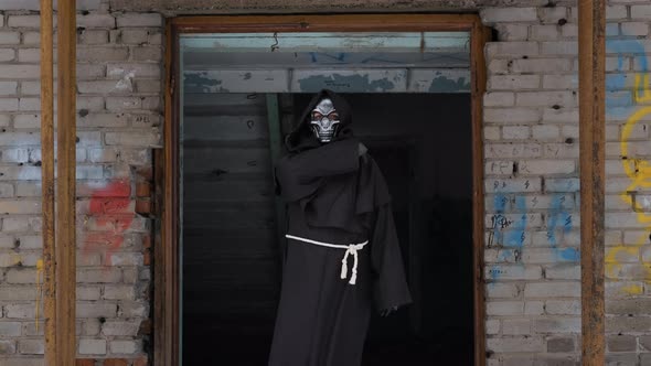 Grim Reaper Runs Finger Across Throat Outdoors alt