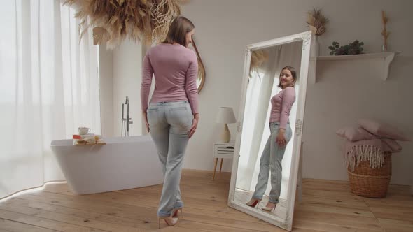 Confident Happy Pretty Female Checking Her Look and Perfect Body Shape in Mirror at Home alt