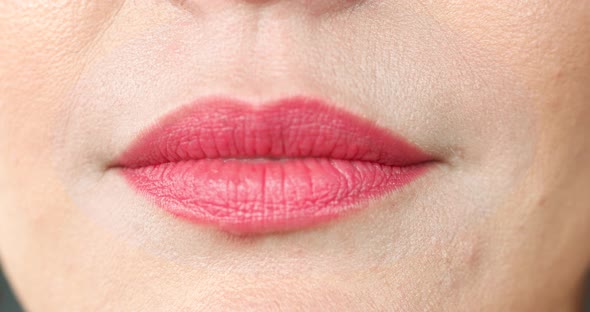 Extreme Close-up Female Mouth with Pink Lipstick Smiling Showing White Healthy Beautiful Teeth