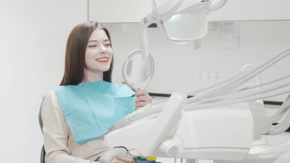 Cheerful Young Woman Smiling to the Camera Sitting in Dental Chair alt