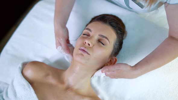 Spa the Professional Beautician Makes Relaxing Massage for Young Girl Skin Care and Cream alt