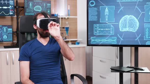 Male Scientist Sitting on a Chair and Using Virtual Reality Goggles alt