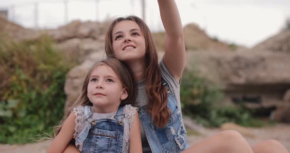 Two Sisters Looking Amazedly on the Sky alt