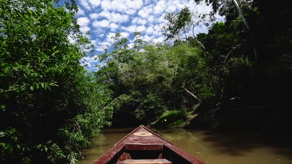 boat moving slowly through a narrow canal in amazon alt