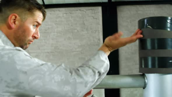 Kung fu fighter practicing martial arts with wooden dummy  alt