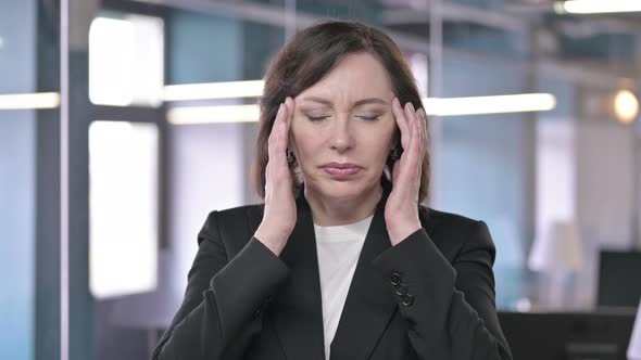 Portrait of Tired Middle Aged Businesswoman Having Headache alt