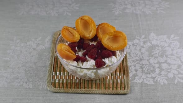 A Bowl of Cottage Cheese Apricots and Raspberries on Top