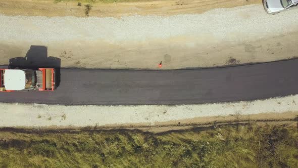 Aerial View of New Road Construction with Steam Roller Machine at Work alt