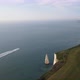 Motorboat navigating along coast of Old Harry Rocks cliffs leaving long white wake, England. Aerial - VideoHive Item for Sale