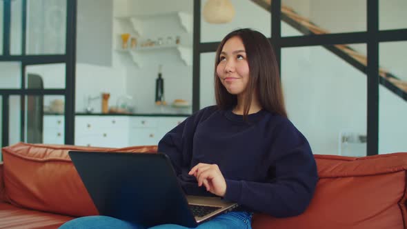 Charming Asian Woman Working on Laptop at Home alt