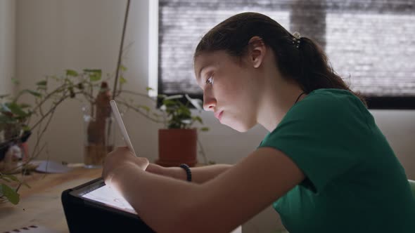 Teenage girl drawing using a tablet computer and an electronic pen alt