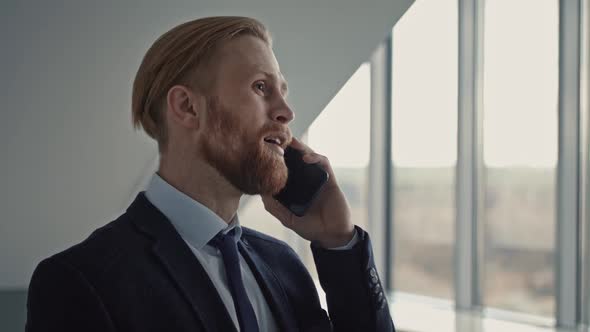 Portrait of Smiling Businessman Answering Phone Call Modern Workplace